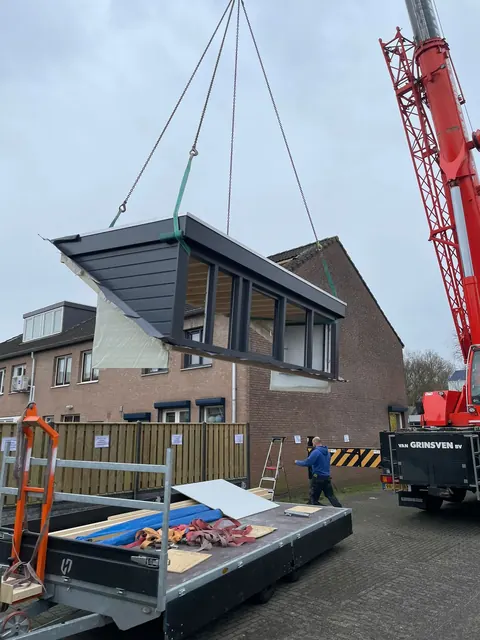 Dakkapel hangt aan de kraan boven de straat