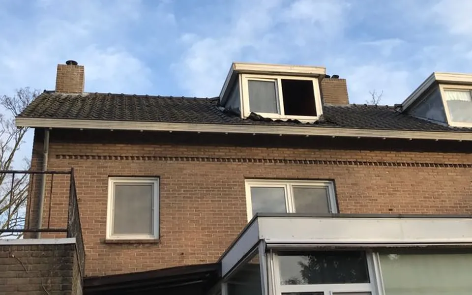 Voor: de oude witte dakkapel met een open raam