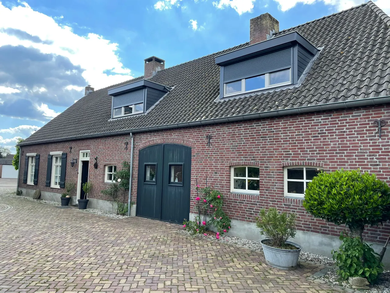 Twee donkere dakkapellen op een Brabantse langgevelboerderij