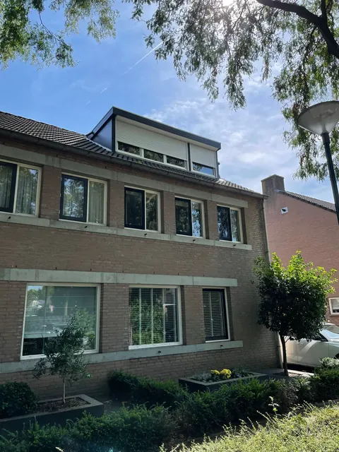 Dakkapel met rolluiken op een woning van drie verdiepingen